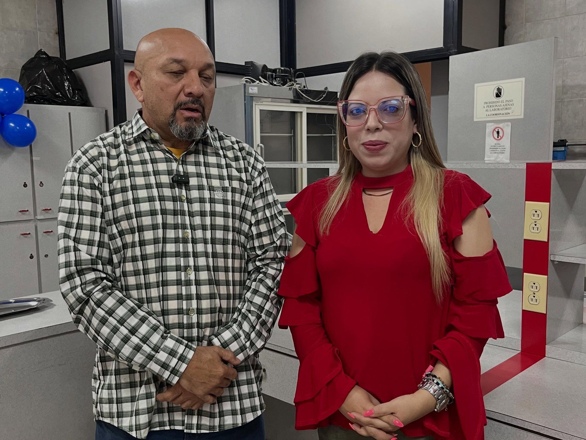 Dos asistentes al acto de entrega conversan en el laboratorio